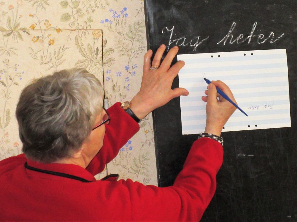 "Fröken" visar hur man skriver med bläckpenna.
